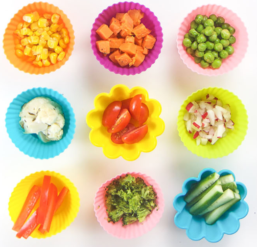 Porciones de verduras y frutas en moldes de colores listas para el método BLW.